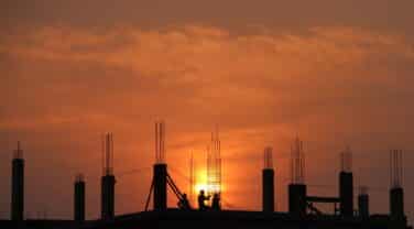 The sun is setting behind a tech construction site.